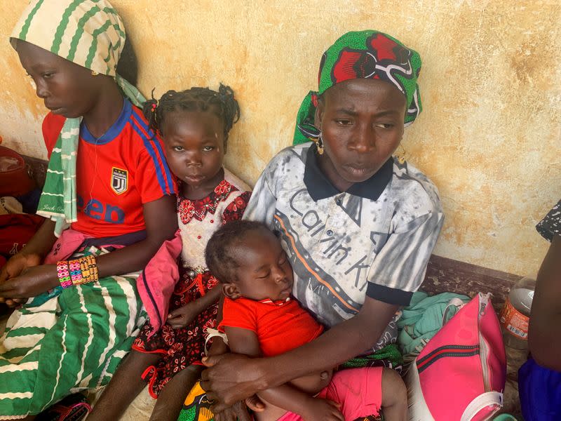 A woman who fled the violent rebellion in Central African Republic (CAR) sits with her family as they wait for their identification process in the border town of Garoua Boulai