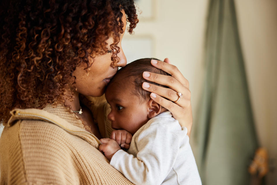 A woman kisses her baby on the head