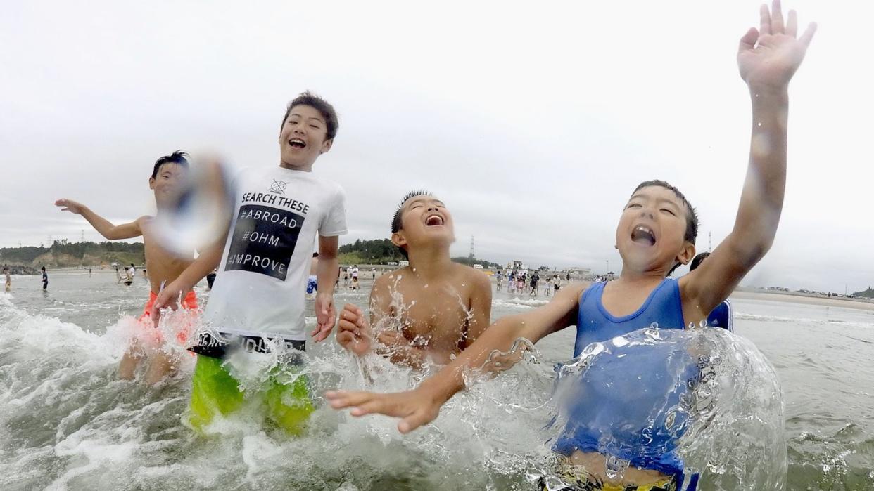 Kinder spielen im Wasser: Nach der Nuklearkatastrophe von Fukushima wurde der Strand zum ersten Mal wieder für Besucher zugelassen. Foto: kyodo