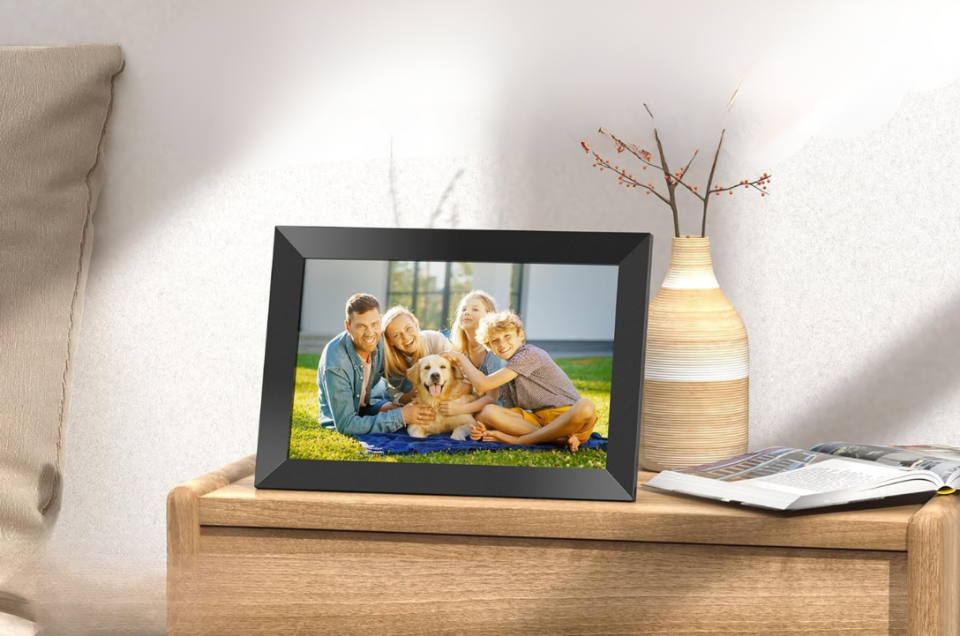 digital photo frame on a table beside a bed