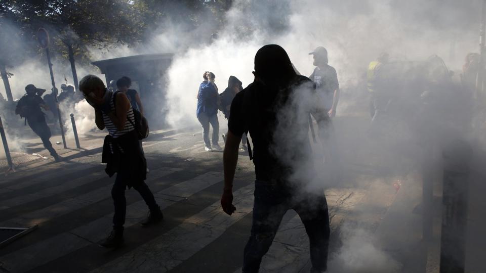 Demonstranten stehen in Paris im Tränengasnebel. Foto: Thibault Camus/AP