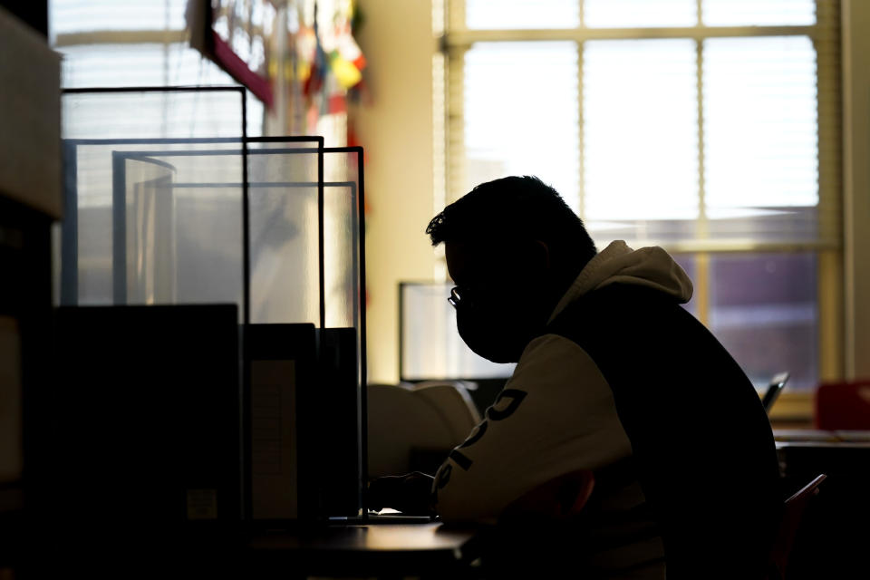 Senior Jose Solano-Hernandez takes a test on the first day of in-person learning at Wyandotte High School in Kansas City, Kan., Wednesday, March 30, 2021. Solano-Hernandez, feared he might not graduate after a year of disrupted learning left him missing assignments in most of his classes as he struggled to learn virtually. The school, like other schools nationwide, has made extra efforts to keep kids at risk of dropping out engaged as classes went virtual due to the pandemic. (AP Photo/Charlie Riedel)