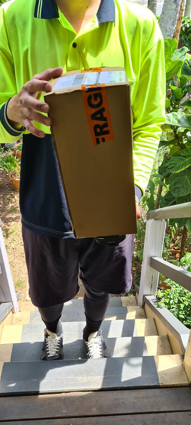 Australia Post worker holds a package. Source: Facebook