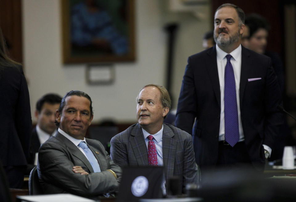 Texas Attorney General Ken Paxton, center, sits between defense attorneys Tony Buzbee, left, and Mitch Little, right, before his impeachment trial resumes in the Senate Chamber at the Texas Capitol on Friday, Sept. 15, 2023, in Austin, Texas. (Sam Owens/The San Antonio Express-News via AP, Pool)