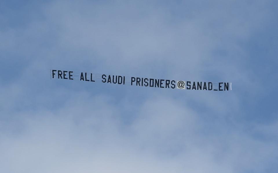 A plane flies over St. James Park towing a banner which reads "Free All Saudi Prisoners @Sanad_en" - Michael Regan/Getty Images