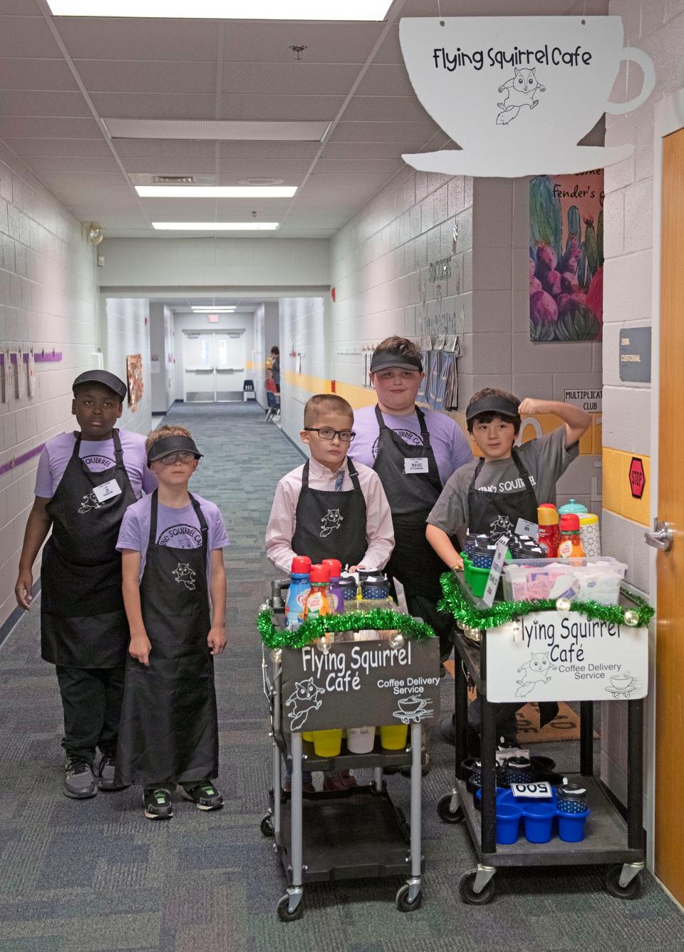 The employees of the Flying Squirrel Café prepare to deliver beverages to teachers and staff throughout Rhodes Elementary School on Friday, Dec. 1, 2023. The student-run business helps the children with learning life and social skills.