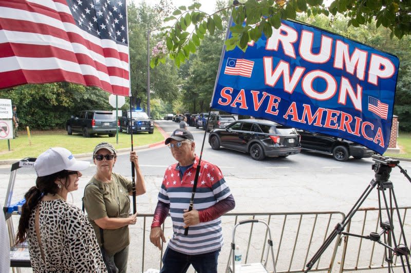 Supporters of former President Donald Trump hold flags outside the Fulton County Jail in Atlanta. Photo by Anthony Stalcup/UPI