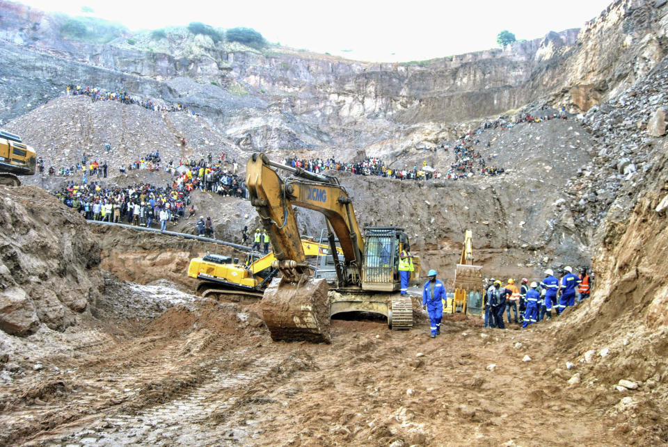 Excavators and people surround the scene of the miners rescue operation on Sunday, Dec. 3, 2023 in Chingola, around 400 kilometres (248 miles) north of the capital Lusaka, Zambia. Seven miners were confirmed dead and more than 20 others were missing and presumed dead after heavy rains caused landslides that buried them inside tunnels they had been digging illegally at a copper mine in Zambia, police and local authorities said Saturday. (AP Photo)