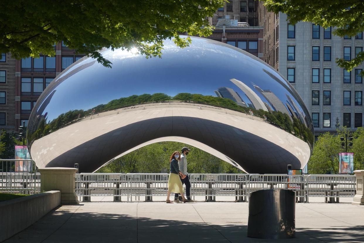 CHICAGO, ILLINOIS - JUNE 15: Visitors walk past the Cloud Gate, also known as "The Bean," sculpture in Millennium Park on June 15, 2020 in Chicago, Illinois.