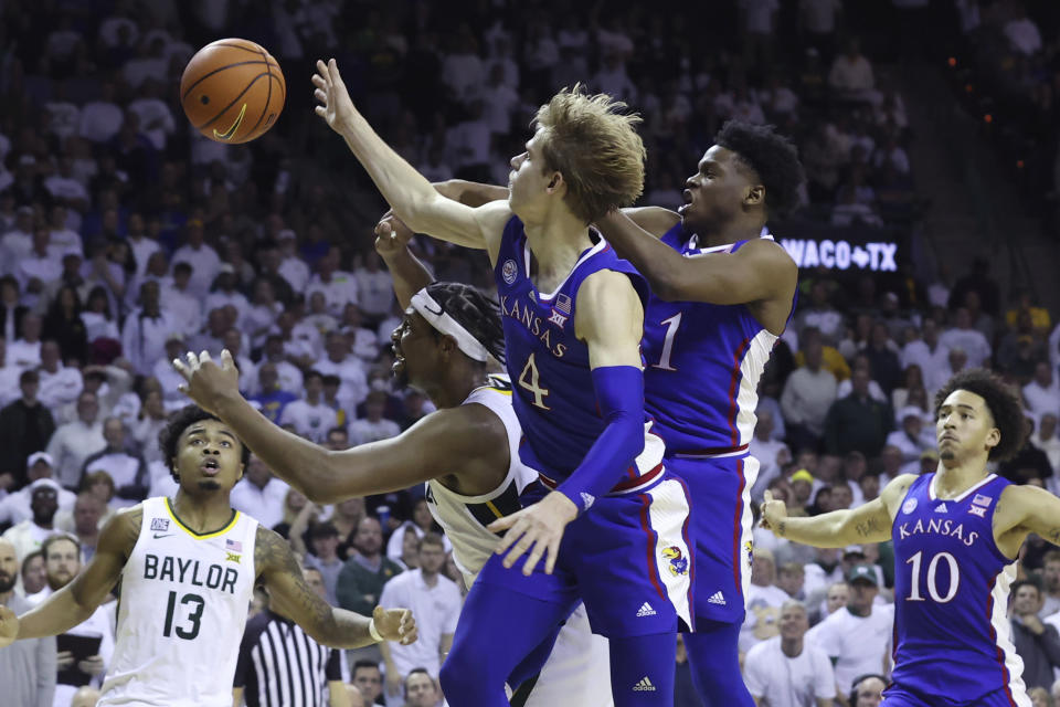 Kansas guard Gradey Dick (4), Kansas guard Joseph Yesufu (1) and Baylor forward Flo Thamba, second from left, reach for the ball during the second half of an NCAA college basketball game Monday, Jan. 23, 2023, in Waco, Texas. (AP Photo/Jerry Larson)