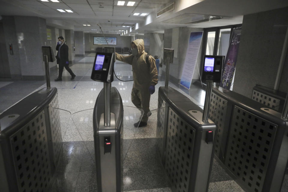 A man wearing protective gear disinfects Health Ministry headquarters because of the new coronavirus, in Tehran, Iran, Saturday, March 7, 2020. (AP Photo/Vahid Salemi)