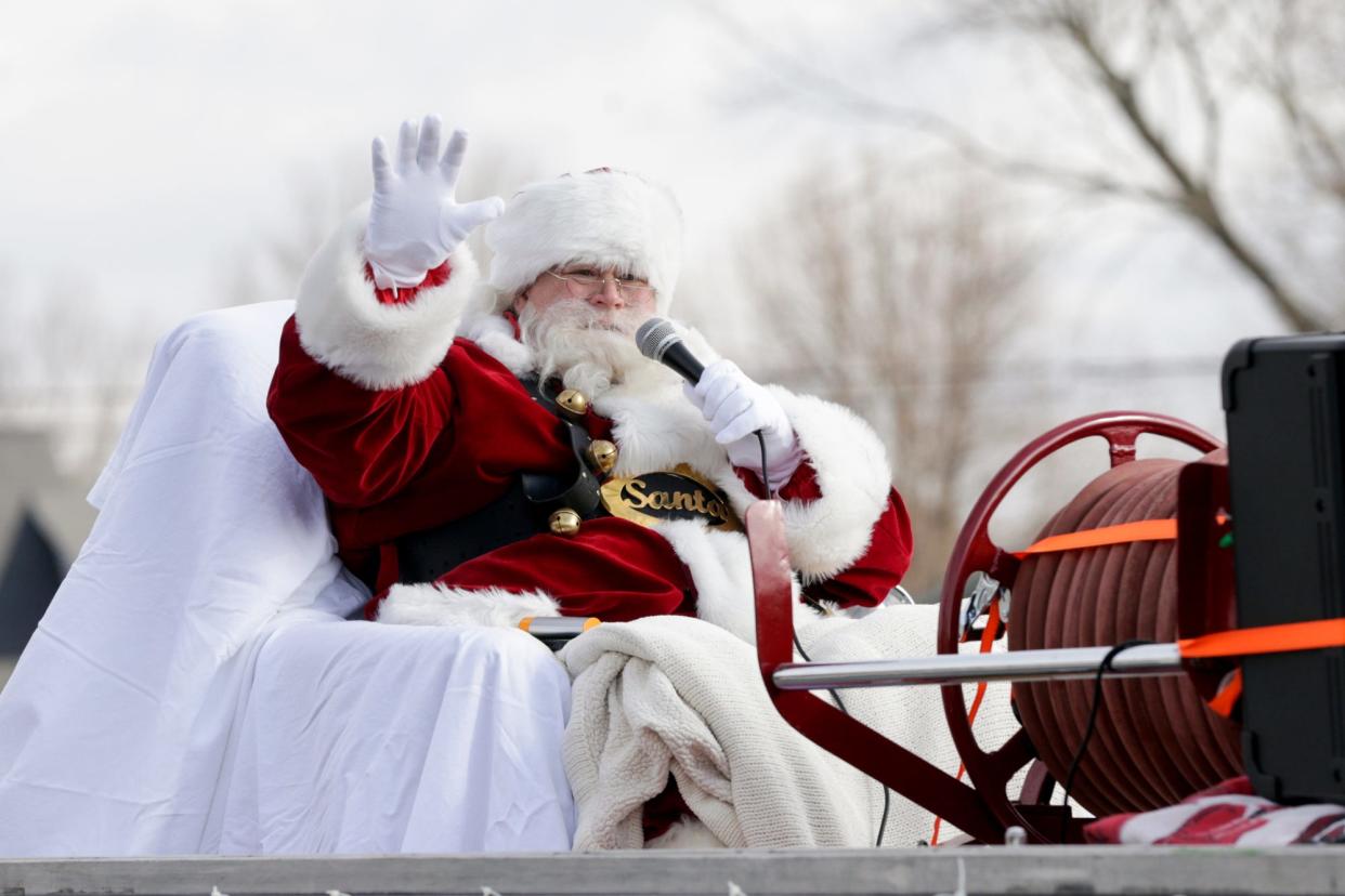 Santa Claus waves to families at Amelia Earhart Elementary School aboard a 1936 Lafayette fire engine, Sunday, Dec. 6, 2020 in Lafayette.