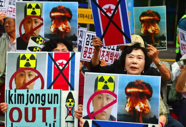 South Korean conservative activists hold placards showing the portrait of North Korean leader Kim Jong-Un during a protest denouncing North Korea's nuclear test in Seoul on September 10, 2016