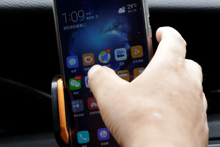 A Didi Chuxing driver prepares to open the application in his car in Beijing, China August 28, 2018. REUTERS/Jason Lee