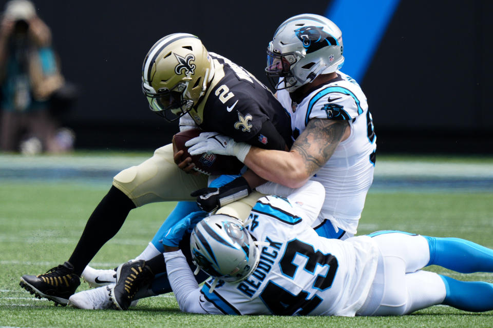 New Orleans Saints quarterback Jameis Winston is sacked by Carolina Panthers defensive end Morgan Fox and outside linebacker Haason Reddick during the first half of an NFL football game Sunday, Sept. 19, 2021, in Charlotte, N.C. (AP Photo/Jacob Kupferman)