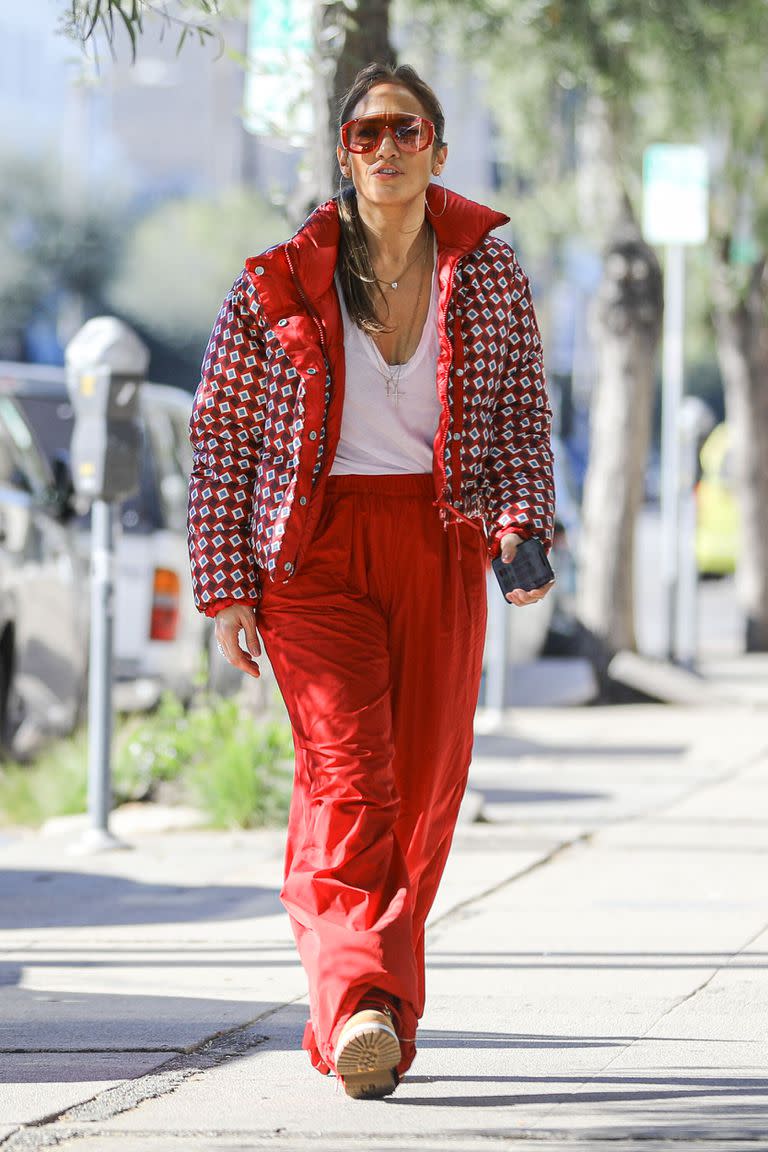 Lady in red. Engamada de pies a cabeza en el color de la Navidad, Jennifer Lopez se vistió de rojo para ir de compras esta semana. Acompañada por su madre, Guadalupe, y su hermana, Linda, la actriz y cantante combinó un pantalón deportivo ancho con una campera estampada inflable y unos anteojos similares a las que se usan para hacer esquí