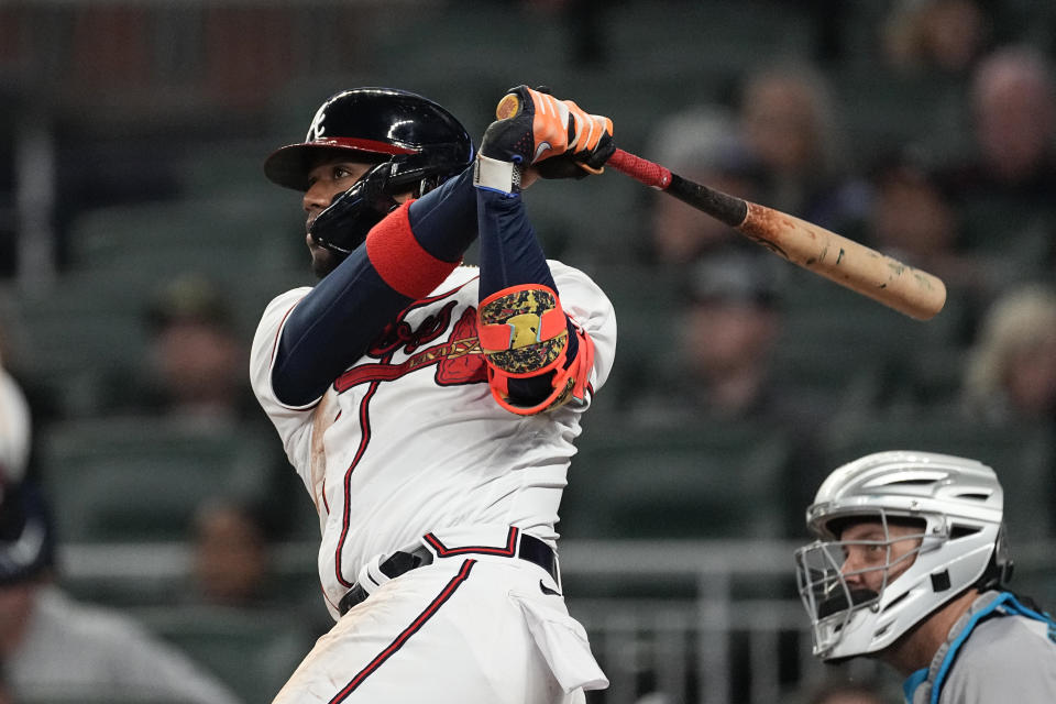 Atlanta Braves' Ronald Acuna Jr. follows through on a solo home run next to Miami Marlins catcher Jacob Stallings during the sixth inning of a baseball game Wednesday, April 26, 2023, in Atlanta. (AP Photo/John Bazemore)