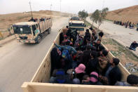 Displaced Iraqi people who have fled their homes because of the clashes sit in military vehicles to take them to safe places as Iraqi forces battle with Islamic State militants in Mosul, Iraq, March 13, 2017. REUTERS/Ari Jalal