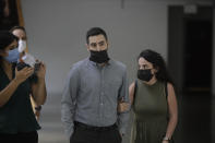 Gali Peleg, right, maternal aunt of Eitan Biran, who survived a cable car crash in Italy that killed his immediate family, arrives to court in Tel Aviv on Thursday, Sept. 23, 2021 for a hearing in the alleged kidnapping of her nephew. The boy's parents and younger sibling were among 14 killed in May when a cable car slammed into a mountainside in northern Italy. He is now the focus of a custody battle between his maternal grandparents in Israel and his paternal relatives in Italy. (AP Photo/Sebastian Scheiner)