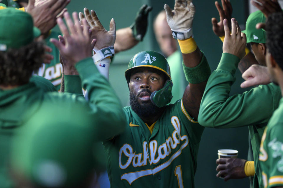 Oakland Athletics' Josh Harrison is congratulated after scoring against the Kansas City Royals during the first inning of a baseball game, Tuesday, Sept. 14, 2021 in Kansas City, Mo. (AP Photo/Reed Hoffmann)