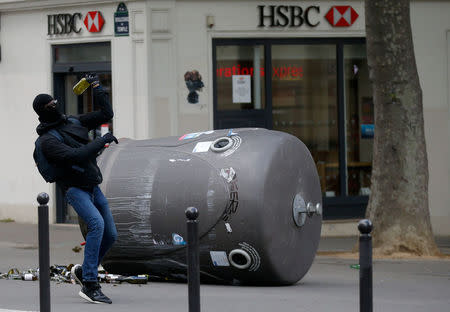 A hooded youth throws a bottle during clashes at a demonstration to protest the results of the first round of the presidential election in Paris, France, April 27, 2017. REUTERS/Gonzalo Fuentes