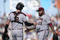 Arizona Diamondbacks catcher Carson Kelly (18) and relief pitcher Reyes Moronta celebrate after the team's 8-4 victory against the San Francisco Giants in a baseball game in San Francisco, Saturday, Oct. 1, 2022. (AP Photo/Godofredo A. Vásquez)