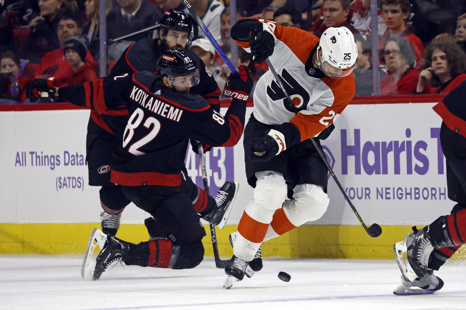 Philadelphia Flyers' Ryan Poehling (25) takes the puck from Carolina Hurricanes' Jesperi Kotkaniemi (82) during the first period of an NHL hockey game in Raleigh, N.C., Wednesday, Nov. 15, 2023. (AP Photo/Karl B DeBlaker)