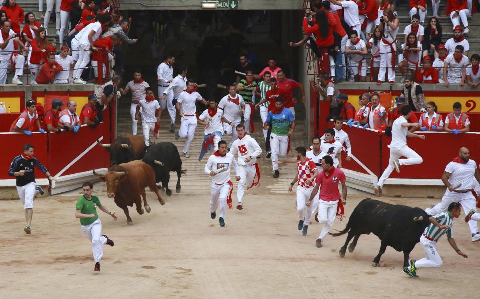 <p>Los toros entrando en la plaza a la carrera junto a los mozos (EFE) </p>