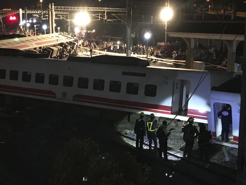 CORRECT COUNTY - Rescue workers gather at the site of a train derailment in Yilan county, northeastern Taiwan on Sunday, Oct. 21, 2018. Passengers were killed and injured on Sunday when one of Taiwan's newer, faster trains derailed on a curve along a popular weekend route, officials said. (AP Photo/Johnson Lai)