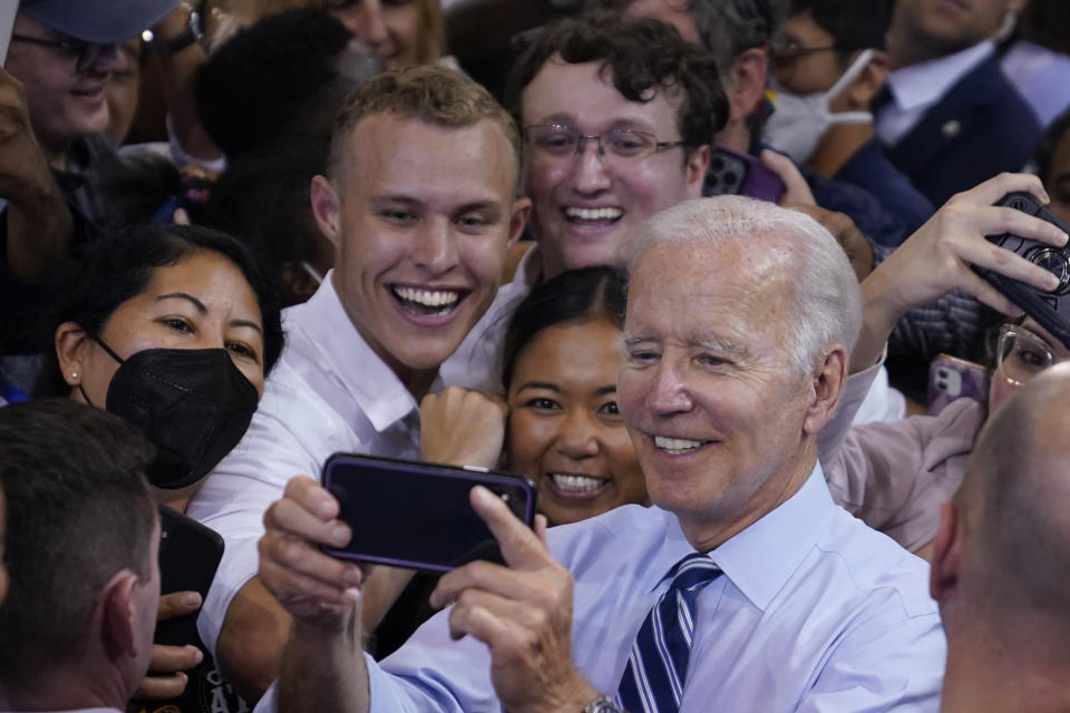 President Joe Biden takes a photo with people after speaking at a rally hosted by the Democratic National Committee at Richard Montgomery High School, Thursday, Aug. 25, 2022, in Rockville, Md. (AP Photo/Evan Vucci)