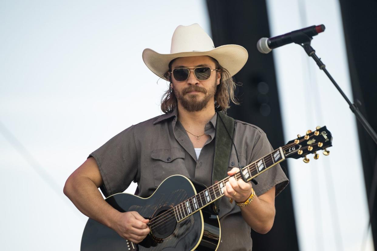 luke grimes on stage at stagecoach festival 2023 with a guitar singing