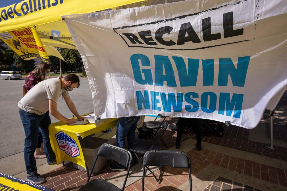 A man signs a petition as conservative activists gather signatures in a recall effort against California Governor Gavin Newsom near Pasadena City Hall, in Pasadena, California on February 28, 2021. (David Mcnew/AFP via Getty Images)