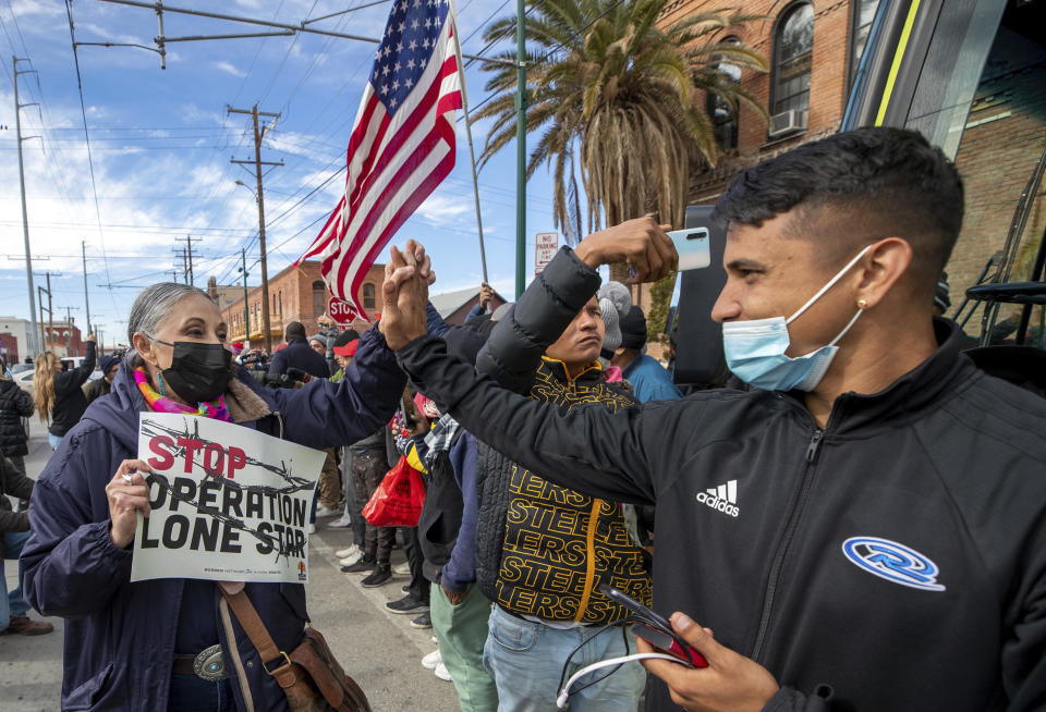 Local activist Rosemary Rojas, left, shakes hands with Venezuelan migrant Johan Padilla while marching in their support in downtown El Paso, Texas, Saturday, Jan. 7, 2023. Several hundred marched through the streets of El Paso a day before President Joe Biden's first, politically-thorny visit to the southern border. (AP Photo/Andres Leighton)