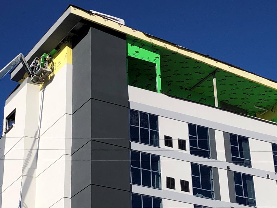 A construction worker works on the exterior of the new Hyatt Place hotel in Arden in spring 2022.