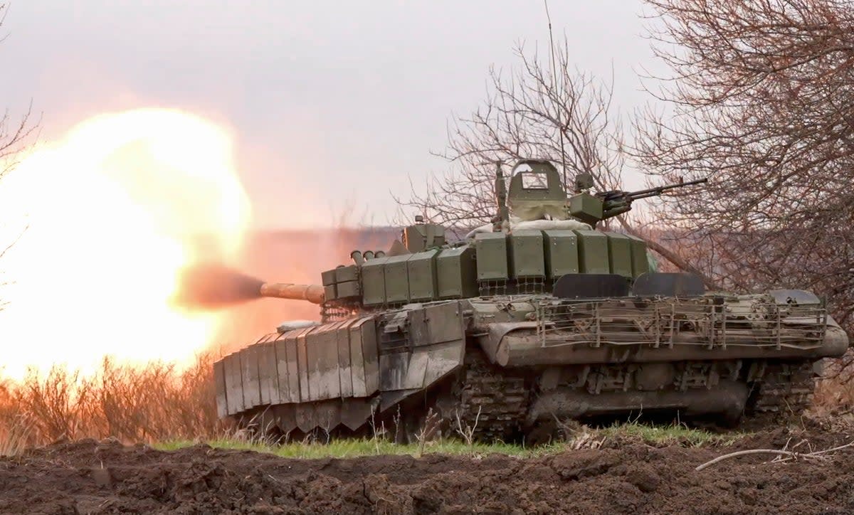 A Russian tank fires at Ukrainian positions on the front line earlier this year, in an image provided by the Russian defence ministry  (EPA)