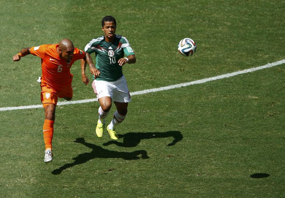 Mexico's Dos Santos fights for the ball with de Jong of the Netherlands during their 2014 World Cup round of 16 game at the Castelao arena in Fortaleza