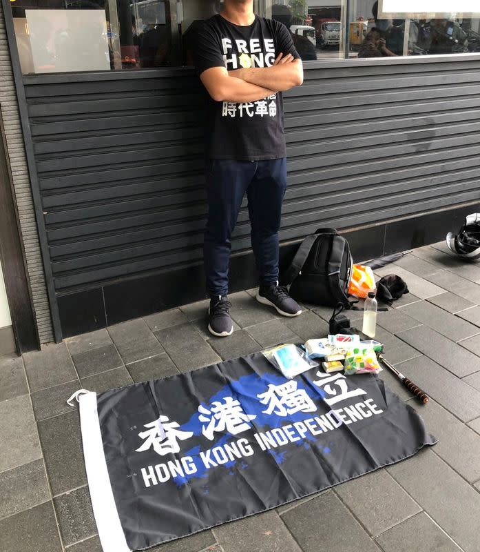 Man stands next to a flag reading "Hong Kong Independence" as people protest the new security law in Hong Kong