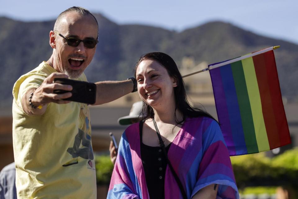 LGBTQ+ employees of Disney, Ruston Harper, left, and Rene Jeske take selfie in front of Walt Disney Company in Burbank.