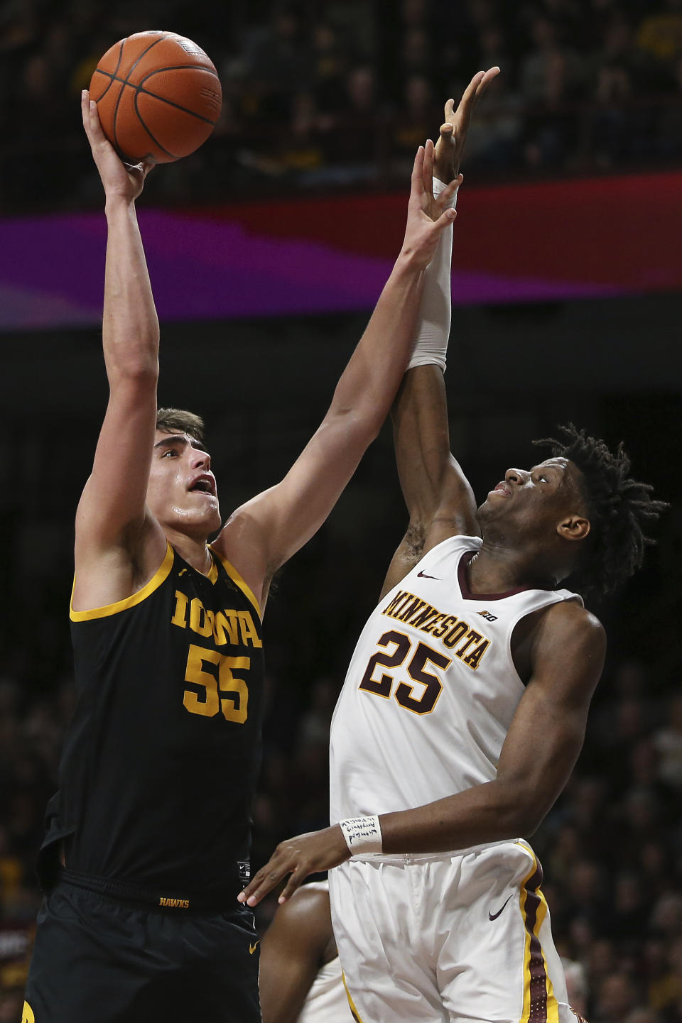 Iowa's Luka Garza, left, shoots against Minnesota's Daniel Oturu during the second half of an NCAA college basketball game Sunday, Feb. 16, 2020, in Minneapolis. (AP Photo/Stacy Bengs)