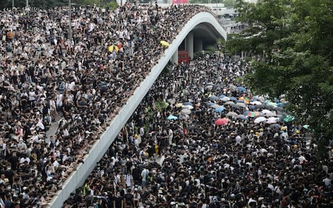 Protesters march along a road demonstrating against a proposed extradition bill in Hong Kong - Credit: Reuters