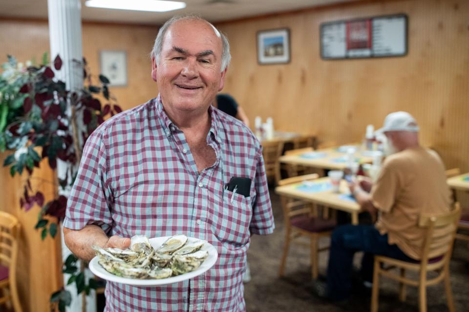Leroy Milligan, owner of Shell Oyster Bar, holds a plate of oysters inside his restaurant Wednesday, May 29, 2024.
