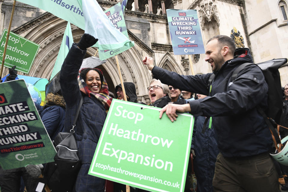 Campaigners cheer outside the Royal Courts of Justice in London, Thursday Feb. 27, 2020. Campaigners have won a court ruling to block the plans for a third runway at Heathrow Airport on environmental grounds. The case before Britain's Court of Appeal could stall the 14 billion-pound ($18 billion) plan to expand Heathrow Airport. (Stefan Rousseau/PA via AP)