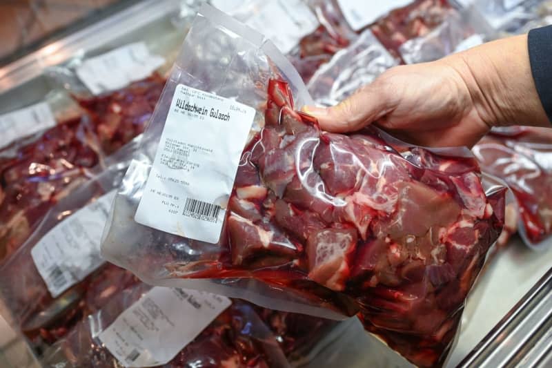 A person takes out a packaged portion of wild boar goulash from the refrigerated counter in the a store. From Thursday, extended rules on origin labelling will apply to meat in the refrigerated counters of German supermarkets and butchers' shops. Uwe Zucchi/dpa