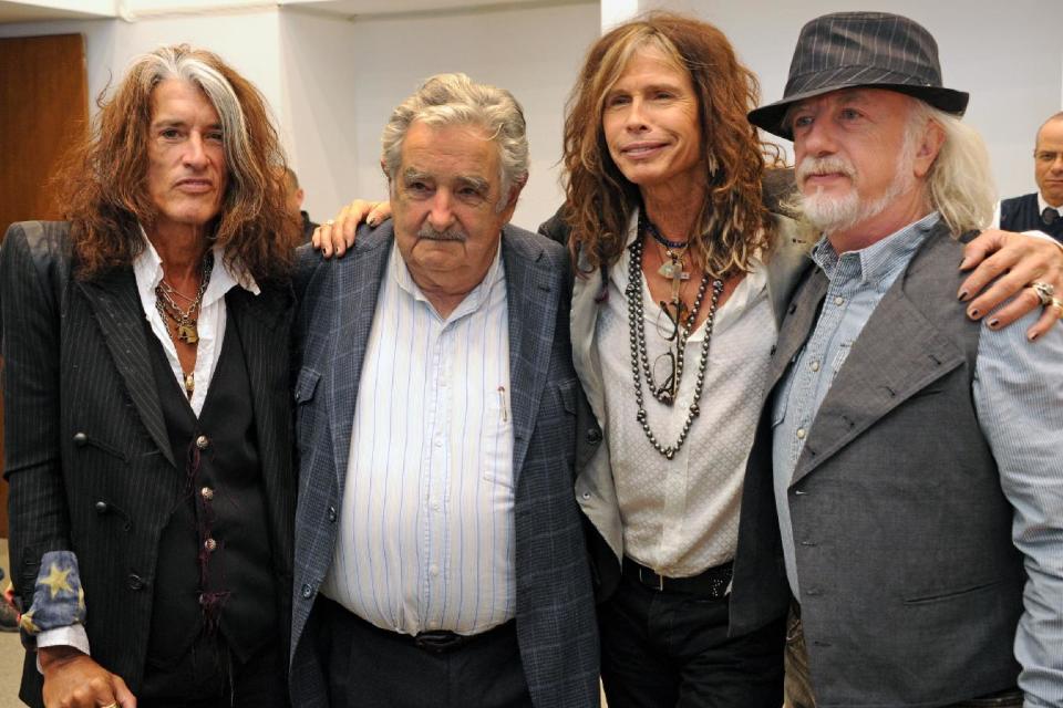 In this picture released by Uruguay's Press Office, Uruguay's President Jose Mujica, second from left, poses with Aerosmith's band members Joe Perry, left, Steven Tyler, second from right, and Brad Whitford after receiving an autographed guitar as a gift at the presidential house in Montevideo, Uruguay, Tuesday, Oct. 8, 2013. The band will perform Wednesday as part of their Latin America tour. (AP Photo/Uruguay Press Office, Alvaro Salas)