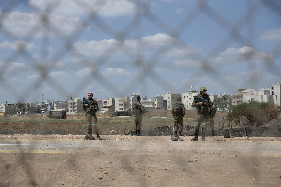 Israeli soldiers stand guard near a damaged section of the Israeli separation fence, that is used by Palestinian laborers to cross into Israel, in the West Bank village of Jalameh, near Jenin, Monday, Sept. 6, 2021. Israel launched a massive manhunt in the country's north and the occupied West Bank early Monday after six Palestinian prisoners tunneled out of their cell and escaped overnight from a high-security facility in an extremely rare breakout. (AP Photo/Nasser Nasser)