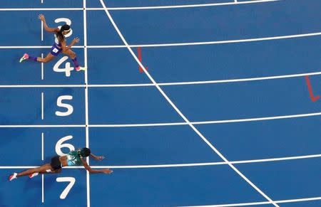 Shaunae Miller (BAH) of Bahamas throws herself across the finish line to win the gold ahead of Allyson Felix (USA) of USA. REUTERS/Fabrizio Bensch