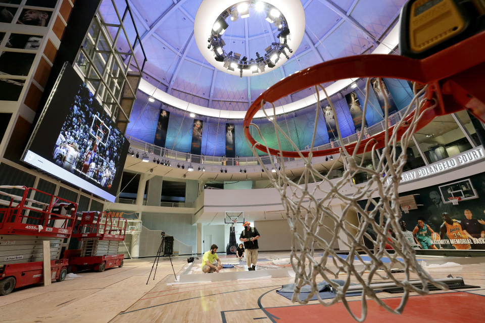 Workers perform restorations at the Naismith Memorial Basketball Hall of Fame, in Springfield, Mass., Tuesday, June 23, 2020. The museum is scheduled to reopen in the beginning of July 2020 with a whole new look after a $22 million renovation. (AP Photo/Steven Senne)