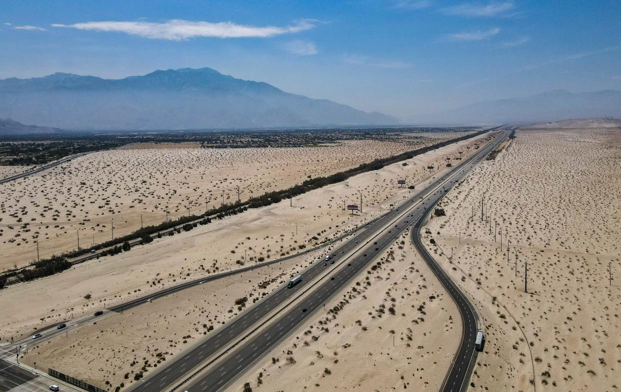 Smoke hangs over Palm Springs as seen from above Interstate 10 and Bob Hope Drive in Thousand Palms on Saturday.