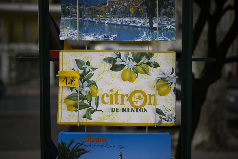 A rack of posters are for sale during the 90th edition of the Lemon Festival in Menton, France on Friday, March 1, 2024. Menton was once a leading lemon-growing region in Europe. (AP Photo/Daniel Cole)