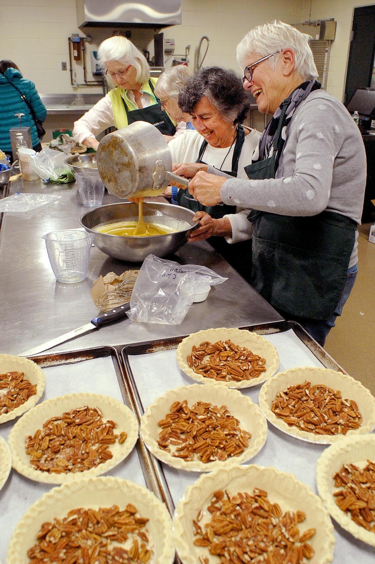 Barbara Wilson, left, and Libby Ellwood, members of the Greenland Women’s Club, mix ingredients for pecan pies at Greenland Central School for the club’s 2019 pie sale.